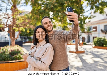 Man and woman couple smiling confident making selfie by the smartphone at park