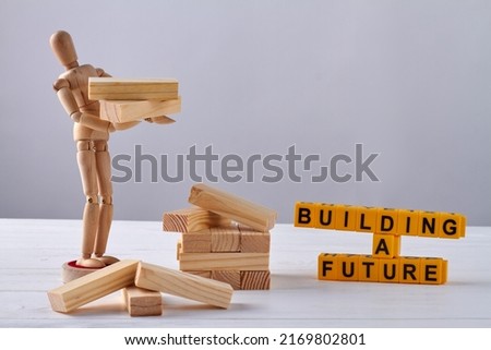 Wooden mannequin holding blocks on white background. Building a future concept.