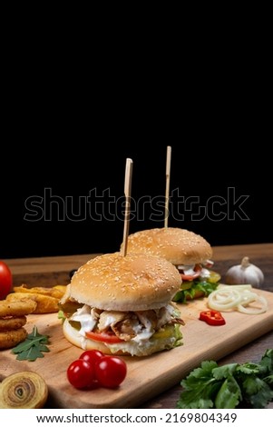 burgers with meat and vegetables on a wooden board