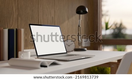 Comfortable home workspace with portable laptop computer blank screen mockup, table lamp and accessories on table over wooden wall. 3d rendering, 3d illustration