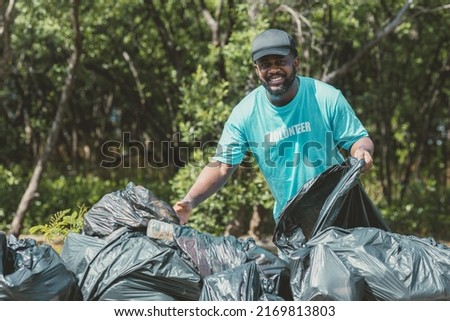 Volunteer man clean up garbage waste in the forest for ecology in Earth day. Royalty-Free Stock Photo #2169813803