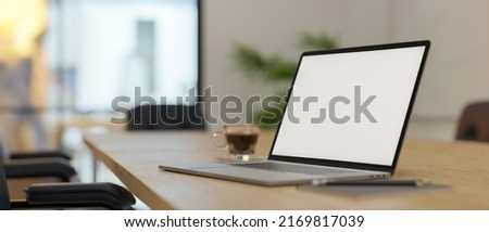 Portable notebook laptop computer white screen mockup on a wooden conference table or meeting table in the meeting room. close-up image. 3d rendering, 3d illustration