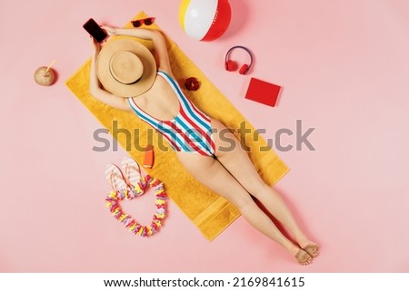 Top back view full body young woman in striped swimsuit lies on towel hotel pool use mobile cell phone with blank screen isolated on plain pink background. Summer vacation sea rest sun tan concept. Royalty-Free Stock Photo #2169841615
