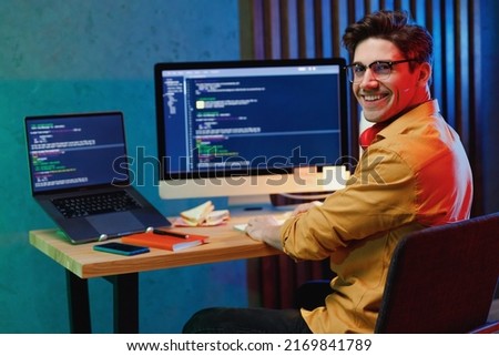 Side back view smiling young full-stack developer software engineer IT specialist programmer man in shirt work at home writing code on laptop pc computer checking database. Program development concept Royalty-Free Stock Photo #2169841789