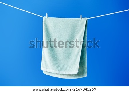 Green towel drying on clothesline Royalty-Free Stock Photo #2169845259