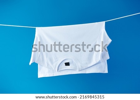 White t-shirt drying on the clothesline Royalty-Free Stock Photo #2169845315