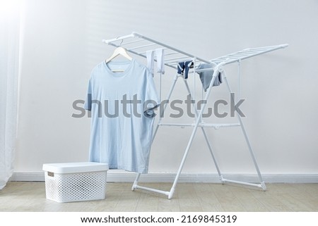 Blue t-shirt drying on the clothesline Royalty-Free Stock Photo #2169845319