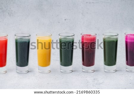Colorful home made detox drinks from dissolved powder in a row on the table. Green, orange, red and purple.