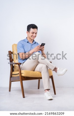 Image of young Asian man sitting on chair Royalty-Free Stock Photo #2169863209