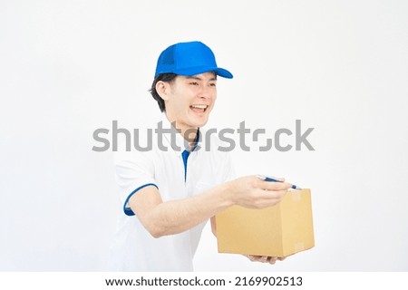 Asian man with a cap and a polo shirt handing cardboard box in white background