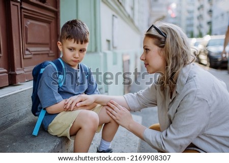 Mother consoling her little son on his first day of school,sitting on stair and saying goodbye before school. Royalty-Free Stock Photo #2169908307