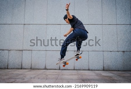 Asian woman skateboarder skateboarding in modern city Royalty-Free Stock Photo #2169909119