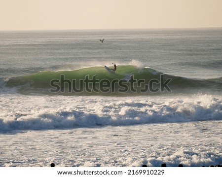 Surfer on wave in surf contest followed by a drone Royalty-Free Stock Photo #2169910229