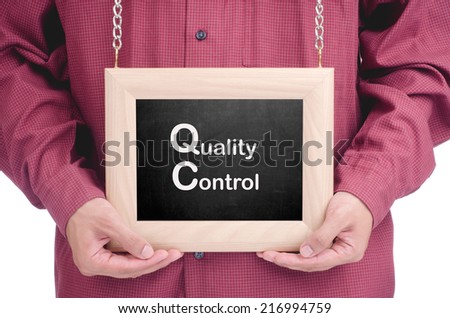 Executive holding a hanging frame with "QUALITY CONTROL" text