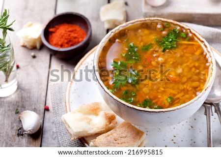 Lentil soup with smoked paprika and bread in a ceramic bowl on a wooden background Royalty-Free Stock Photo #216995815