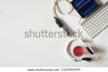 Podcasting concept, headphone, vintage microphone and computer keyboard on white background, free copy space