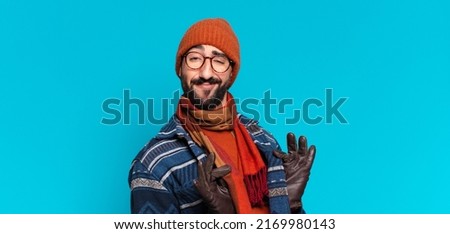 young crazy bearded man proud expression and wearing winter clothes