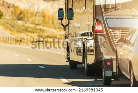 Class A Diesel Pusher Recreational Vehicle. RV Motor Coach with Pull Vehicle on a Highway. Travel in a Motorhome. Royalty-Free Stock Photo #2169981045