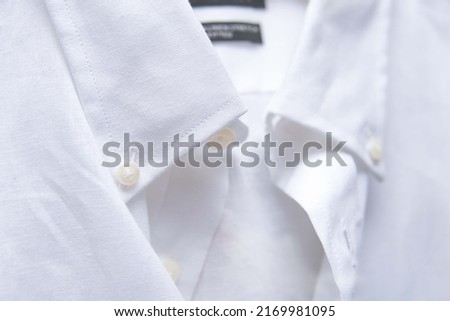 a close-up of a button-down collar on a white oxford shirt