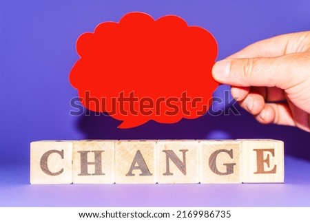 Word Change spelled on wooden dices and man palm holding paper cloud blank space over purple veri peri background.Copy space.