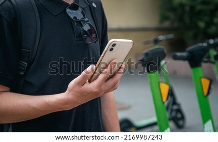 A man unlocks an e-scooter with his mobile phone.