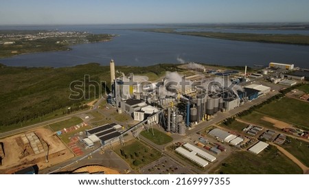 Paper mill factory in front of Uruguay River at Fray Bentos. Aerial panoramic view Royalty-Free Stock Photo #2169997355