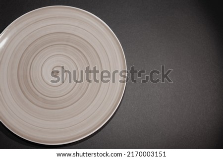 black and white photo of a plate on a black background