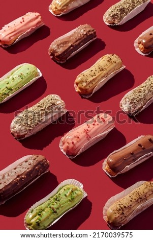 Sweet food pattern of eclairs with color topping. Sweet shacks, minimalism Royalty-Free Stock Photo #2170039575