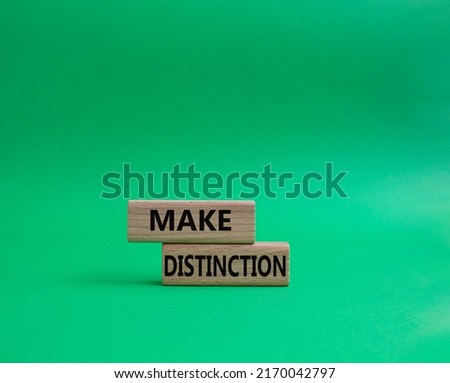 Make distinction symbol. Concept words make distinction on wooden blocks. Beautiful green background. Business and make distinction concept. Copy space.