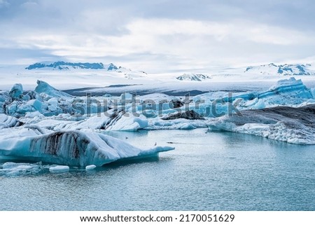 Beautiful icebergs floating in glacial lake. Scenic view of glacial ice formations against cloudy sky. Idyllic scenery of Jokulsarlon glacier lagoon during polar climate. Royalty-Free Stock Photo #2170051629
