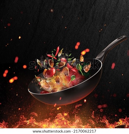 Flying pan isolated on fire background. Creative chef template.  Royalty-Free Stock Photo #2170062217