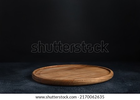 Black background with wooden pizza board Royalty-Free Stock Photo #2170062635