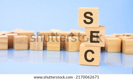 SEC. wooden cubes. blocks lie on a black background. stacks with coins. inscription on the cubes is reflected from the surface of the table. selective focus.