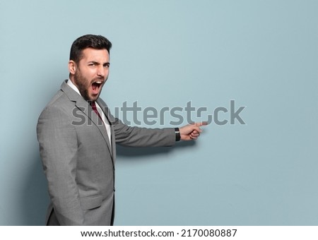young handsome businessman pointing or showing an empty place to yout concept