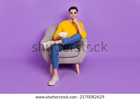 Full size photo of young positive peaceful man watch 3d film enjoying yummy snack isolated on violet color background