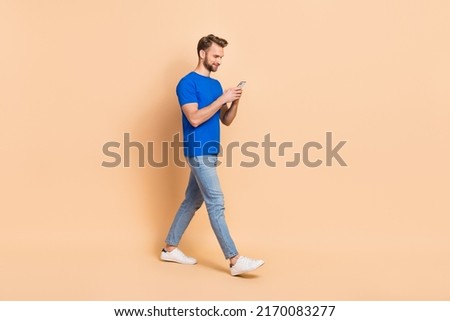 Full size profile photo of attractive positive person walking write post isolated on beige color background