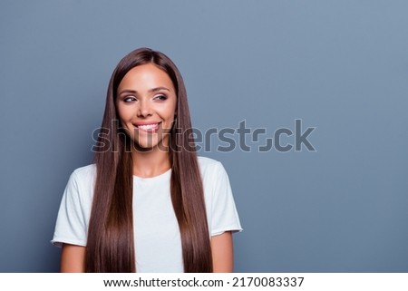 Portrait of minded creative charming girl biting lip look interested empty space isolated on grey color background