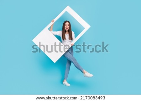 Full length body size view of attractive cheerful girl dancing holding frame having fun isolated over bright blue color background