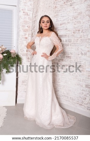 Bride in a white dress against a brick wall. High quality photo