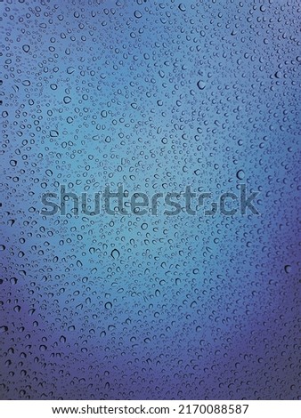 Raindrops on the top window (glass).
Water drops on blue background.