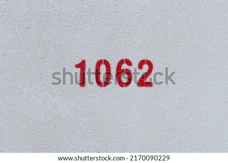 Red Number 1062 on the white wall. Spray paint.
