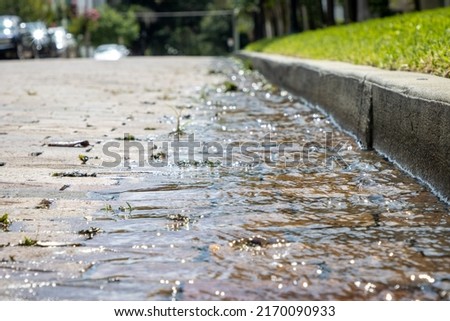 Water running over bricks after heavy rain storm in a city. Storm runoff. Royalty-Free Stock Photo #2170090933