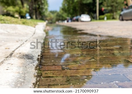 Water running over bricks after heavy rain storm in a city. Storm runoff. Royalty-Free Stock Photo #2170090937