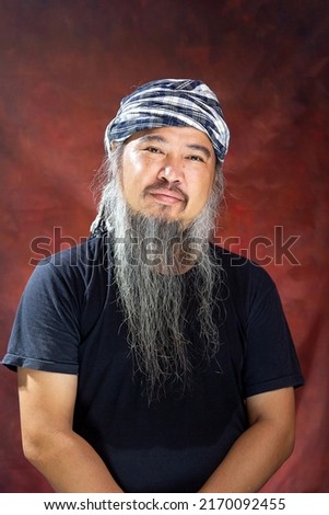Portrait of Thai male farmer with long beard and headband