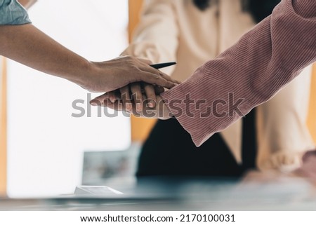 Group of business people putting their hands working together on wooden background in office. group support teamwork agreement concept.