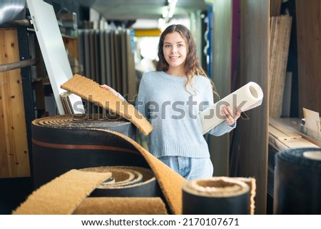 Woman consumer choosing carpet in a hardware store