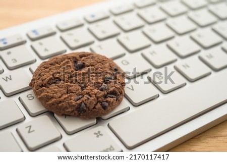 Chocolate chip cookies on keyboard computer background copy space. Cookies website internet homepage policy accepted or blocks concept.