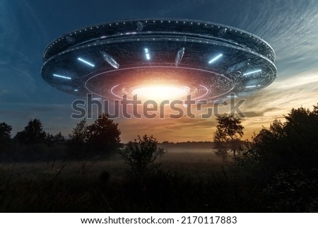 UFO, an alien saucer hovering above the field in the clouds, hovering motionless in the sky. Unidentified flying object, alien invasion, extraterrestrial life, space travel, spaceship. mixed media Royalty-Free Stock Photo #2170117883
