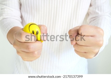 Hands of man with a gentle personality He exhibits stressful behavior from work, and he squeezes the yellow ball expressing emotion, anger, displeasure. Medical concepts and emotional regulation Royalty-Free Stock Photo #2170137399