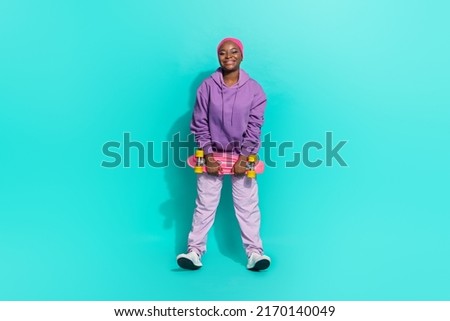 Full length body size view of attractive cheerful girl holding skate fooling having fun isolated over bright teal turquoise color background